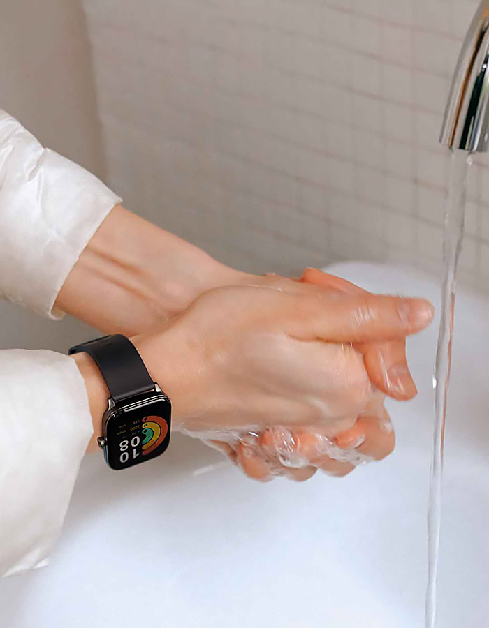 Un hombre lleva el reloj inteligente Haylou GST y se lava las manos