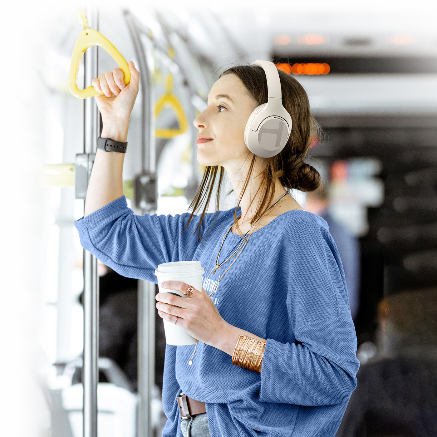 Mujer sosteniendo una taza de café y escuchando música con auriculares Haylou S35 ANC