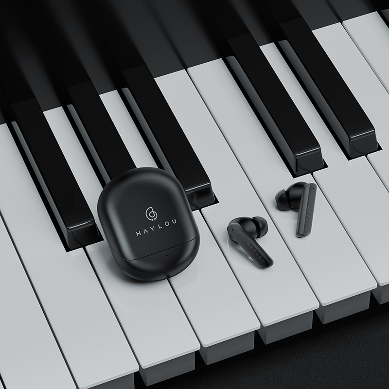 Foto de los auriculares Haylou X1 Pro y su funda en un piano