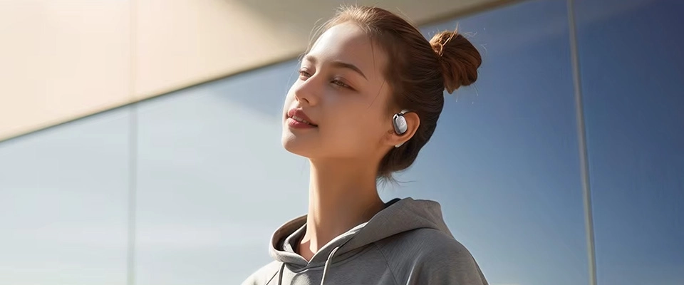 Walking woman listening to music with Haylou Earhook 1 earphones