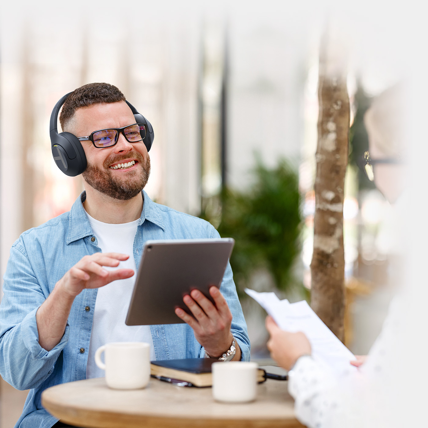 Man holding tablet and listening to Haylou S35 ANC headphones