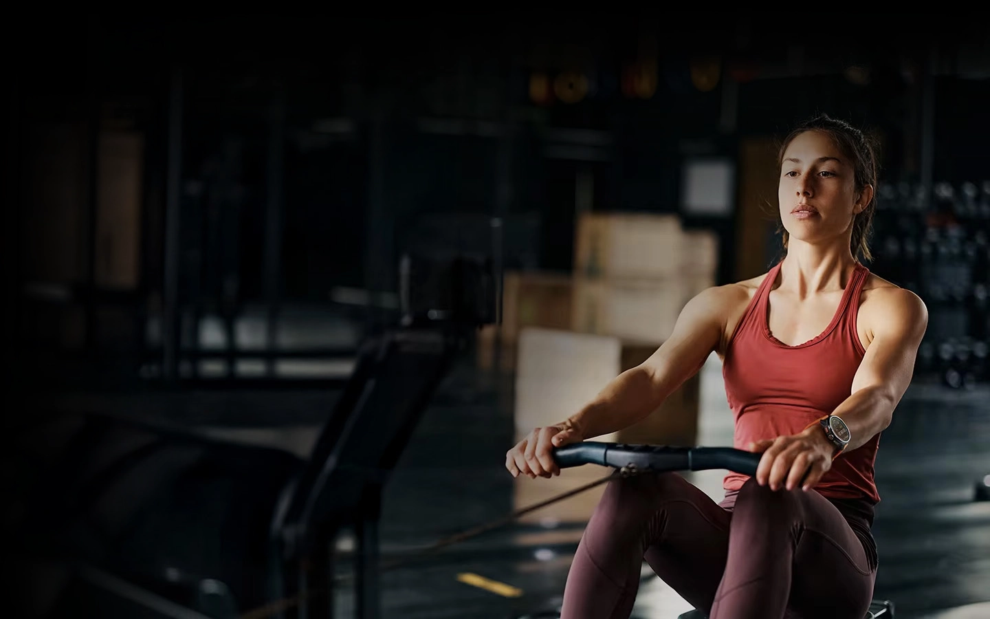 A woman on a rowing machine using Haylou Solar Ultra