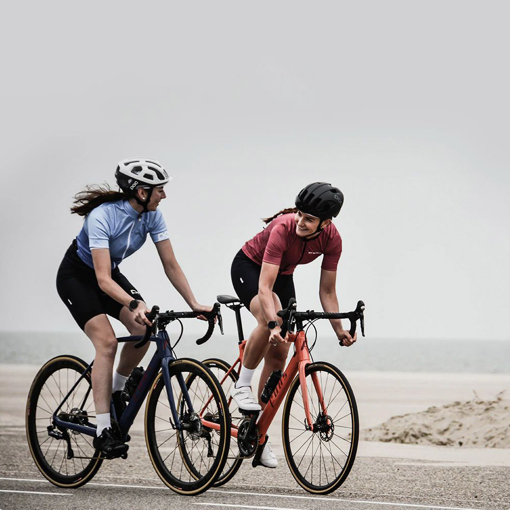 Two women ride bicycles